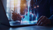 © Kateryna - A professional sitting at a desk, using a laptop while interacting with a 3D holographic bar chart. The chart shows yearly data from 2019 to 2025, with the highest bar for 2025 hig