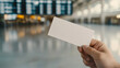 © Bonsales - Man holding an empty boarding pass with airport departure board in the background