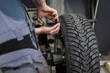© Михаил Решетников - Mechanic removes wheel balance weight from car wheel.