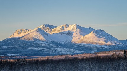 Wall Mural - A snow-covered mountain range under a clear sky, with soft light highlighting the ridges