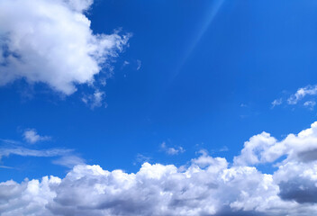 Clear blue sky texture and white fluffy cloud nature background. The sun shines bright in the daytime in summer