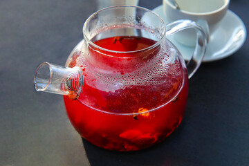 Wall Mural - Red hot fruit tea brewed in a glass teapot