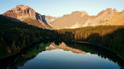 Wall Mural - The tranquil mountain lake reflects the colorful forest at sunset, creating a peaceful oasis in the  of 