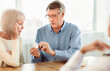 © Prostock-studio - Medical Prescription. Senior man with his wife looking at pills at doctor's office, copyspace
