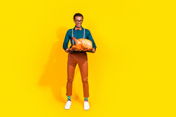 Canvas Print - Photo of positive guy look hold big tasty roasted turkey for thanksgiving event isolated yellow color background