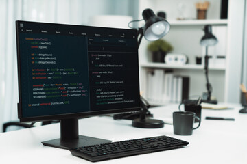 Programming code on computer screen desktop placing on working desk showing intelligent website development coder system running database online with information technology design concept. Infobahn.