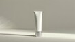 © Miftakhul - A white tube with a silver cap stands on a clean, light-colored surface. .