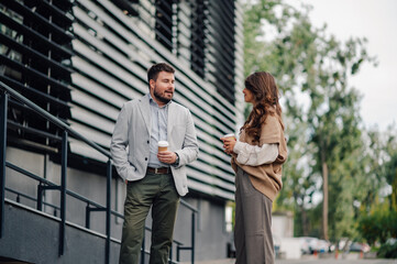 Business partners enjoying a coffee break outside the office building