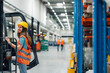 © Zamrznuti tonovi - Female warehouse worker climbing onto forklift in busy warehouse