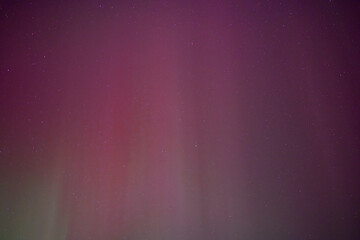 Wall Mural - a night sky filled with light purple and red aurora with patches of green. sky only.