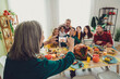 © deagreez - Photo of charming happy big family celebrating thanksgiving day woman photographing friendly family indoors room home