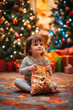 © Canvas Alchemy - A young child sits on a colorful rug, joyfully holding a festive bag of goodies in a cozy, decorated living room during the holiday season