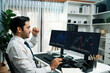 © Summit Art Creations - Successful in trader businessman with two stock exchange investment screens, raising fist up to earn high profit on working desk, dynamic financial technology graph in stock market at office. Surmise.
