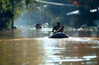 © Andrei - Man with dog escaping from flood using inflatable boat