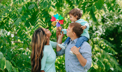 Wall Mural - African american family having fun at the park, mother, father is playing with his son. Care or happiness in family