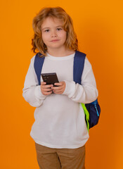 Fototapete - School child sending message texting using smarpthone over yellow isolated background.