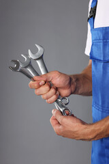 Wall Mural - Auto mechanic with wrenches on grey background, closeup