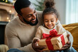 © KirKam - Father and daughter joyfully holding a present box.