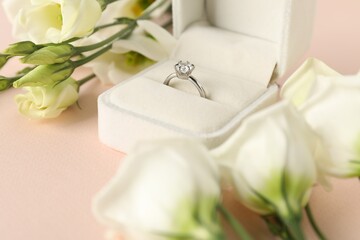 Poster - Beautiful ring with gemstone in box and flowers on pink background, closeup