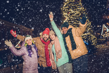 Wall Mural - Portrait of group funny excited buddies arms waving hi have good mood x-mas evening lights outdoors