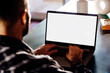 © AlexPhotoStock - Over shoulder view of a young business man using computer laptop in front of an blank white computer screen in his home living room. Photo ready for mockup.