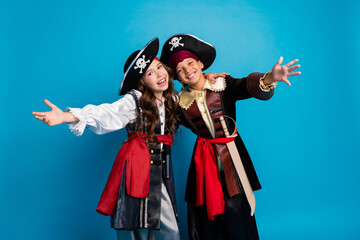 Poster - Photo of two small kids embrace arms welcome you wear halloween pirate costume isolated on blue color background