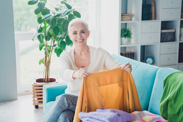 Photo of positive pretty woman dressed white cardigan cleaning home folding tidy clean fresh clothes relocation indoors