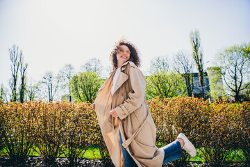 Wall Mural - Photo of cheerful adorable optimistic girl wearing trendy beige trench weekend promenade spring weather outdoors