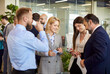 © Studio Romantic - A group of business people talking in the hall and laughing, close-up. Young businessmen exchange contacts. Concept of business acquaintance, meeting in the lobby of a conference room