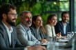 © Sitthikorn - Group of colleagues engaging in a discussion during a business meeting in a conference room. Happy business people, men and women