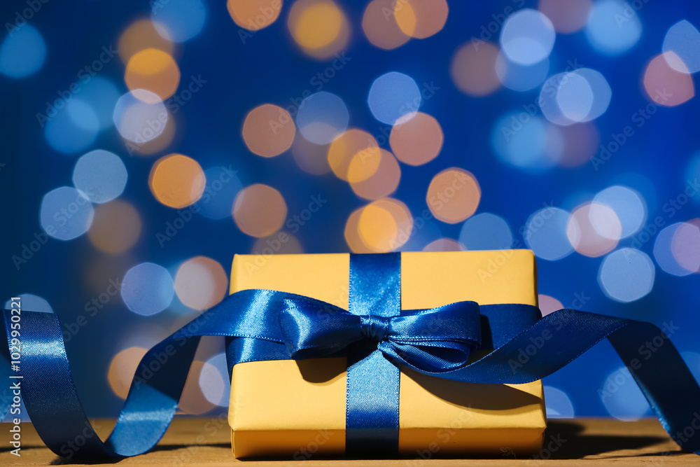 Christmas gift box on wooden table against blurred lights