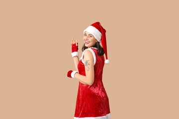 Canvas Print - Happy young woman in Santa Claus costume on brown background