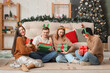 © Pixel-Shot - Group of young friends with Christmas gifts at party