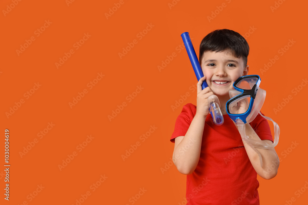 Cute little boy with swimming mask on red background