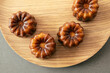 © Cavan Images - Four Golden French Canelé Fresh From The Oven