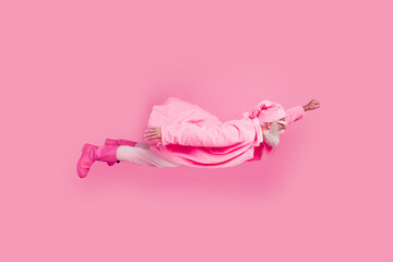 Full body profile portrait of funky aged man raise fist flying wear glamour clothes isolated on pink color background