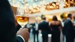 © Wannaeka - Elegant group of people at a high-ceiling party, savoring wine in a stylish setting with string lights.