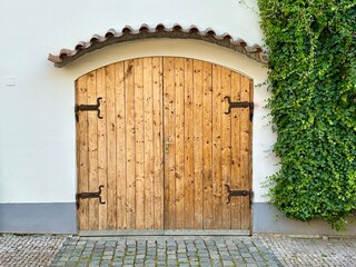 The photograph captures a close-up of an old medieval gate, crafted from wood and metal, set in the charming streets of a historic European city.