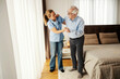 © Dusan Petkovic - Full length shot of senior man trying to walk at nursing home and nurse is holding him and helping.