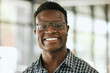 © peopleimages.com - Portrait, smile and black man in office, glasses and ambitious for business, proud and expert of project. Entrepreneur, happy and person in company, professional and consultant in finance and Nigeria