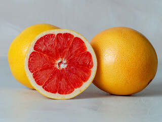 grapefruit group of fruits cut in half, red interior light background, red – bitter, sour, juicy taste