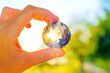 © Katie Chizhevskaya - Hand Holding Globe Puzzle with Sun Rays Coming Through the Missing Pieces