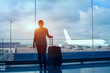 © Song_about_summer - silhouette of woman passenger waiting in airport with suitcase, international travel by plane, tourism and immigration