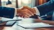 © Galib - Two businessmen shaking hands over a contract.