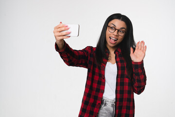 Young friendly positive african woman girl female student 20s doing selfie shot on mobile cell phone talking by video zoom call waving hand greeting isolated on white background studio portrait