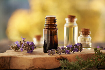 Wall Mural - A brown bottle of essential oil with blooming lavender plant