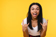 © InsideCreativeHouse - This festival rocks. Enthusiastic excited crazy african woman girl female student having fun on concert winks show rock-n-roll heavy metal sign screaming from joy and thrill isolated yellow background
