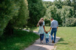 © ShunTerra - Happy African-American and European family walking and playing together in the park. Black family walking down the road holding hands