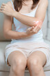 © Jo Panuwat D - Arthritis and Muscle Pain Relief Cream concept. Woman having elbow ache at home, muscle pain due to lateral epicondylitis or tennis elbow. injury, Health and medical concept