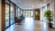 © Mirjana - Spacious nursing facility corridor with large windows, seating areas, and greenery during daylight hours